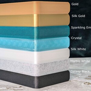 May include: A stack of rectangular blocks in various colors, including gold, silk gold, sparkling emerald, crystal, silk white, marble white, and galaxy black. Each block is labeled with its color name.
