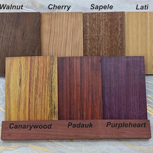 A collection of solid wood faceplates for the 2026 Steam Machine, made from genuine wood, displayed on a marble and gold background.