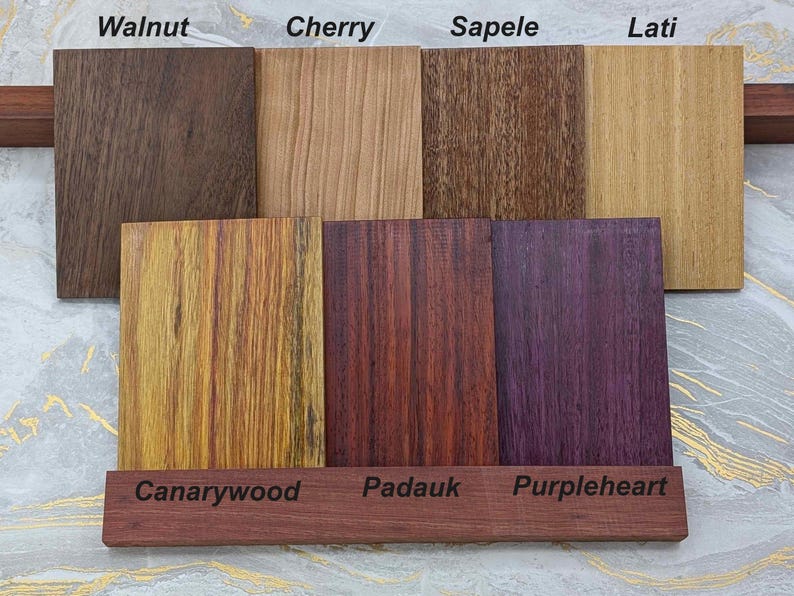 A collection of solid wood faceplates for the 2026 Steam Machine, made from genuine wood, displayed on a marble and gold background.