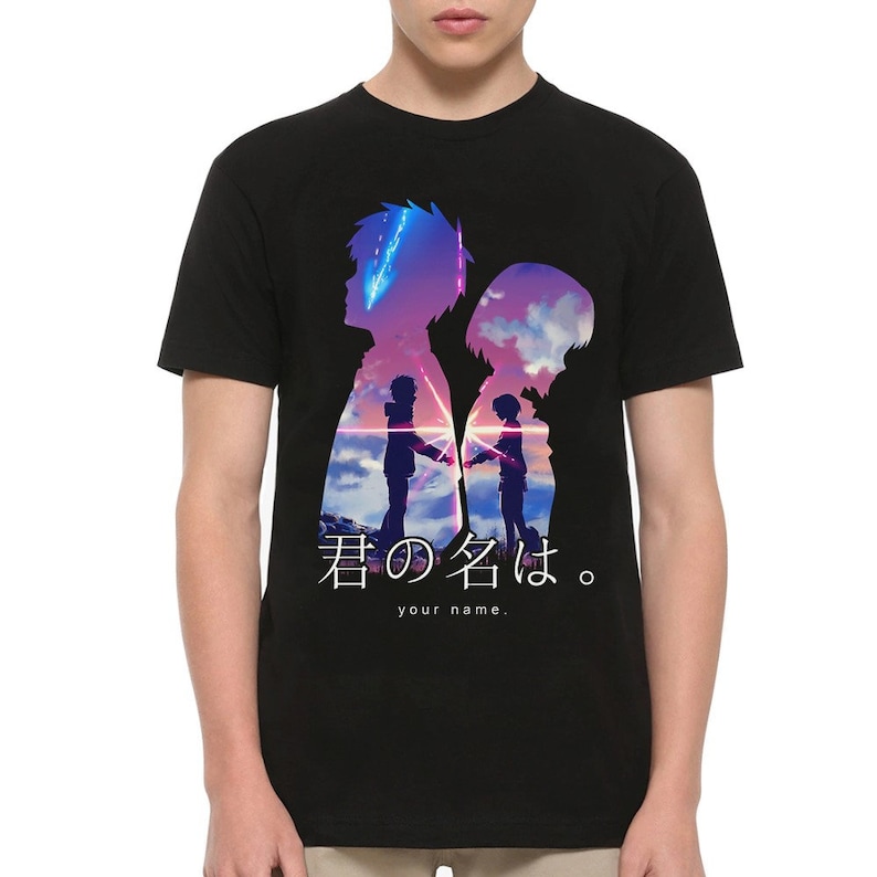 May include: Black t-shirt featuring a silhouette design with two figures against a colorful sky background. The Japanese text "君の名は。" and the English text "your name." are printed below the figures.