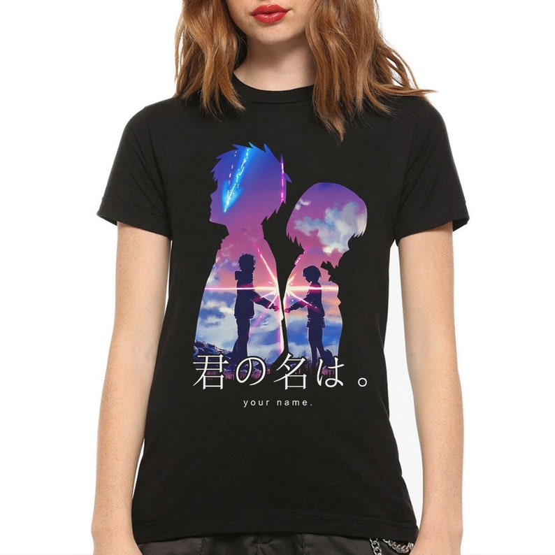 May include: Black t-shirt featuring a silhouette design with two figures holding hands against a sunset backdrop. The shirt includes Japanese text and the English phrase "your name."