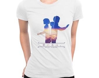 May include: White t-shirt featuring a silhouette design of two figures with a sunset backdrop. The Japanese text "君の名は。" and English text "your name." are printed below the design. The shirt is made of a soft material.