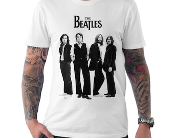 Op de afbeelding: Wit T-shirt met een zwart-wit afbeelding van The Beatles. De naam van de band, "The Beatles", is in een zwart, gestileerd lettertype boven de afbeelding gedrukt. De afbeelding toont de bandleden in zwart-witte kleding.