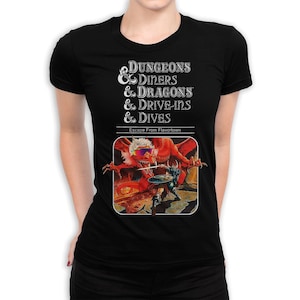 May include: Black t-shirt featuring the text "Dungeons & Diners & Dragons & Drive-Ins & Dives" above a graphic of a red dragon wearing sunglasses. The graphic is from "Escape From Flavortown".