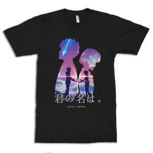 May include: Black t-shirt featuring a silhouette design with two figures, a vibrant sky, and the Japanese text "君の名は。" and the English text "your name." The design includes a colorful sunset and two figures holding hands.