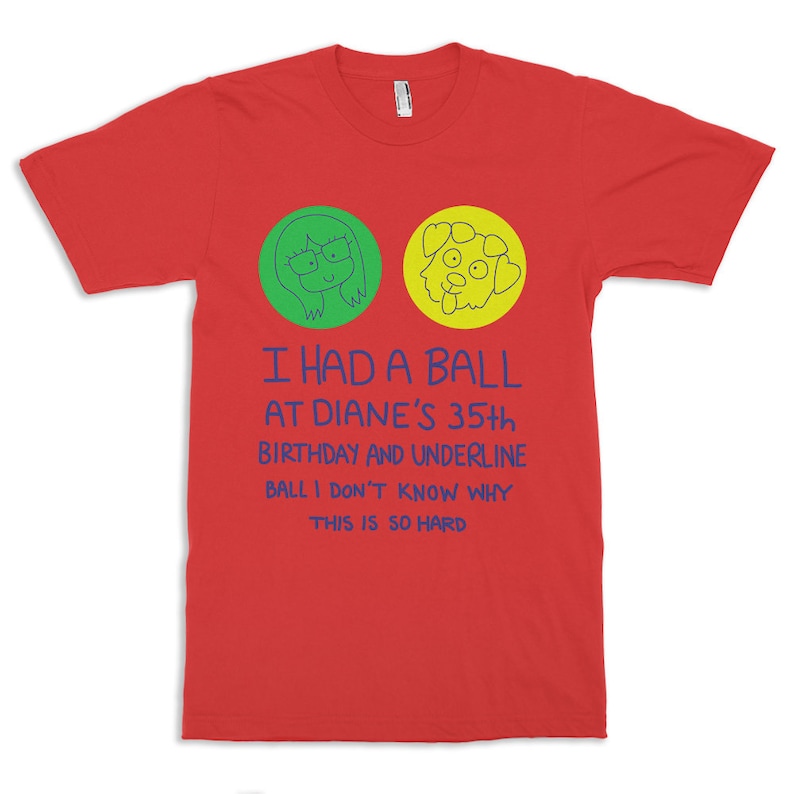 May include: A red t-shirt with a graphic design. The design includes two cartoon circles, one green with a woman's face and one yellow with a dog's face. Below the circles is blue text that reads "I HAD A BALL AT DIANE'S 35th BIRTHDAY AND UNDERLINE BALL I DON'T KNOW WHY THIS IS SO HARD."