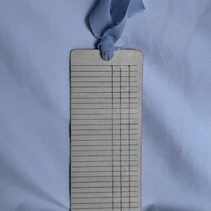 The back side of a bookmark from a straight on view. Does not include any of the titles but also has the ribbon