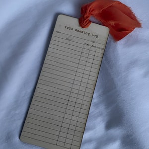 The front side of a bookmark from a straight on view. Shows booktitles, when you started the book, end time, and what your rating would be of the book. You can date your reading list bookmark!