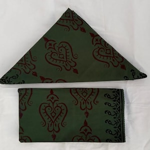 Peut inclure: Deux serviettes en tissu vertes avec un motif marron répété. L'une est pliée en triangle, l'autre est rectangulaire. Les bords de la serviette rectangulaire ont une bordure décorative.