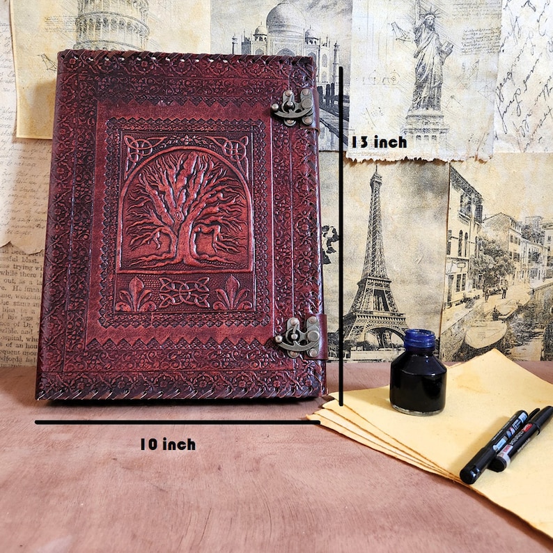 以下が含まれることがあります： 木の生命のデザインと金属製の留め具が付いた茶色の革のジャーナル。ジャーナルの幅は10インチ、高さは13インチです。