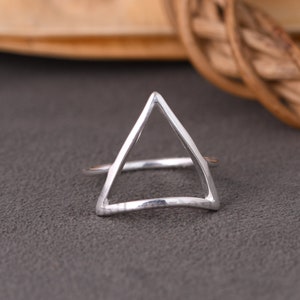Peut inclure: Une bague en argent en forme de triangle avec un design simple et minimaliste.