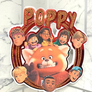 Può includere: Topper per torta con glitter rosso e oro con la parola "POPPY" in un cerchio. Il centro del cerchio presenta un panda rosso e personaggi del film "Turning Red".