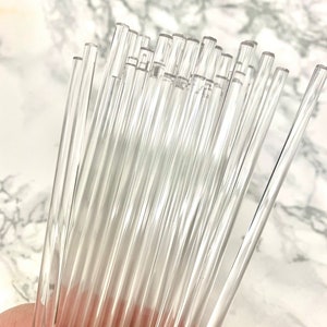 May include: A bundle of clear glass rods, approximately 12 inches long, for crafting and art projects.