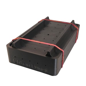 Może przedstawiać: Czarny plastikowy pojemnik z otworami i czerwoną gumką. Pojemnik ma nadrukowany napis "Urban Fungi" na boku.