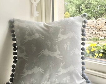 Grey leaping hares design cushion covers with pom-poms