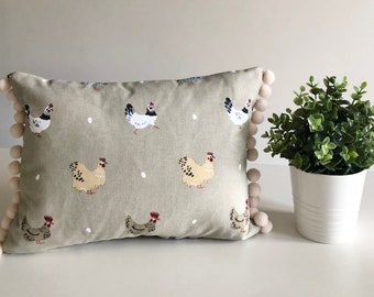 Sophie Allport Lay a little egg design cushion with pom-poms