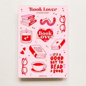 Könnte beinhalten: Ein rosa Stickerbogen mit roten Illustrationen von Büchern, Brillen, einer Kerze und einer Kaffeetasse. Der Text "Book Lover" ist herzförmig, und der Satz "It's a good day to read a book" ist ebenfalls enthalten.