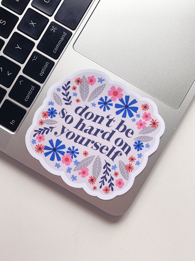 Puede incluir: Una pegatina con un dise&ntilde;o floral y el texto "no seas tan duro contigo mismo".
