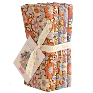 Könnte beinhalten: Ein Bündel quadratischer Stoffstücke mit Blumenmuster in Braun-, Orange-, Blau- und Lilatönen, gebunden mit einem cremefarbenen Band. Der Stoff weist ein sich wiederholendes Muster stilisierter Blumen auf. Ein Etikett mit dem Text "Wild Flower Collection" ist angebracht.
