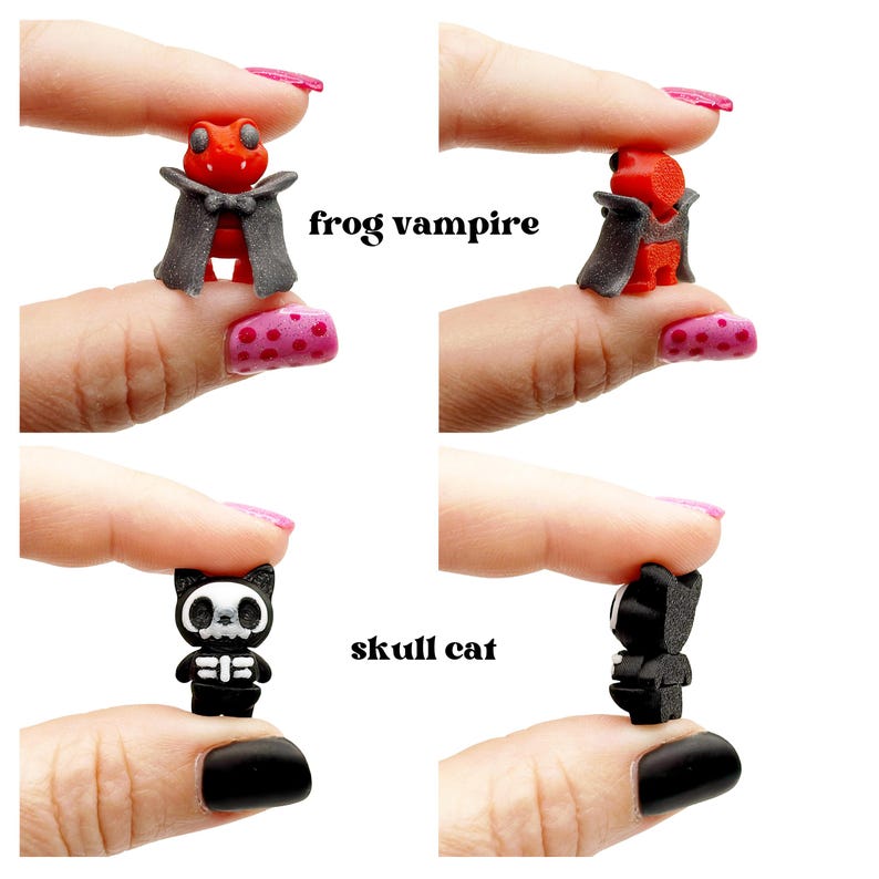 Peut inclure: Deux figurines miniatures : une grenouille vampire rouge portant une cape grise et un chat noir avec un visage en forme de cr&acirc;ne blanc et un motif de cage thoracique. Le texte frog vampire et skull cat est imprim&eacute; &agrave; c&ocirc;t&eacute; des figurines.