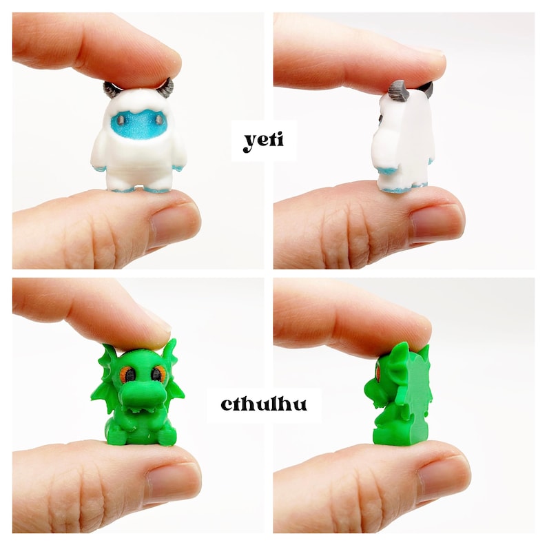 May include: Miniature figurines of a yeti and a Cthulhu. The yeti is white with blue accents and small horns. The Cthulhu is green with orange eyes and wing-like features. The word "yeti" and "cthulhu" are printed on the image.