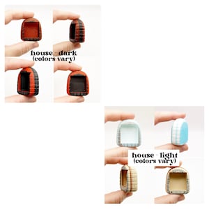 May include: A collection of miniature house-shaped figurines in various colors. The dark-colored houses are red, black, and orange. The light-colored houses are blue, white, and beige. The text "house - dark (colors vary)" and "house - light (colors vary)" are visible.