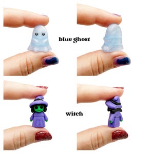 Peut inclure: Une petite figurine de fant&ocirc;me bleu avec des yeux noirs et une finition translucide, et une petite figurine de sorci&egrave;re avec un visage vert, des cheveux noirs, un chapeau et une robe violets. Le texte blue ghost et witch est imprim&eacute;.