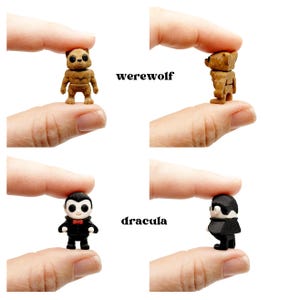 Peut inclure: Deux figurines miniatures, un loup-garou marron et un dracula noir et blanc, chacune montr&eacute;e de face et de profil. Le loup-garou pr&eacute;sente des d&eacute;tails de fourrure textur&eacute;e, tandis que le dracula porte un costume noir, un n&oelig;ud papillon rouge et un visage p&acirc;le. Les &eacute;tiquettes werewolf et dracula sont pr&eacute;sentes.