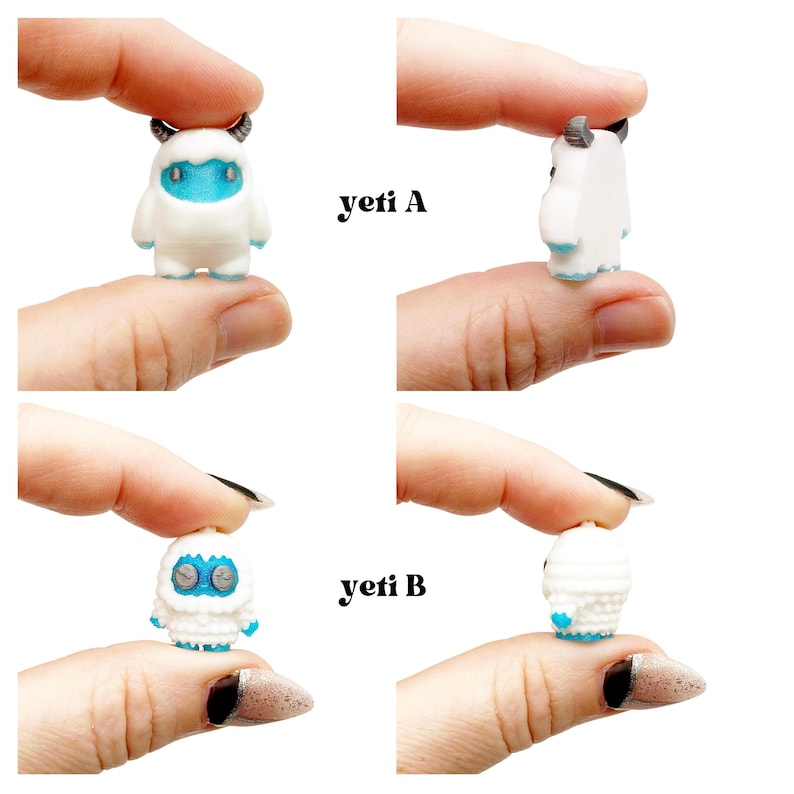May include: Miniature white yeti figurines with blue accents and small horns are displayed. The text "yeti A" and "yeti B" are visible. The figurines are held up by fingers, showcasing the size and detail of the small sculptures.
