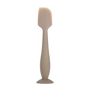 May include: A light brown silicone spatula with a rounded head and a long handle. The handle has a textured grip and a suction cup base.