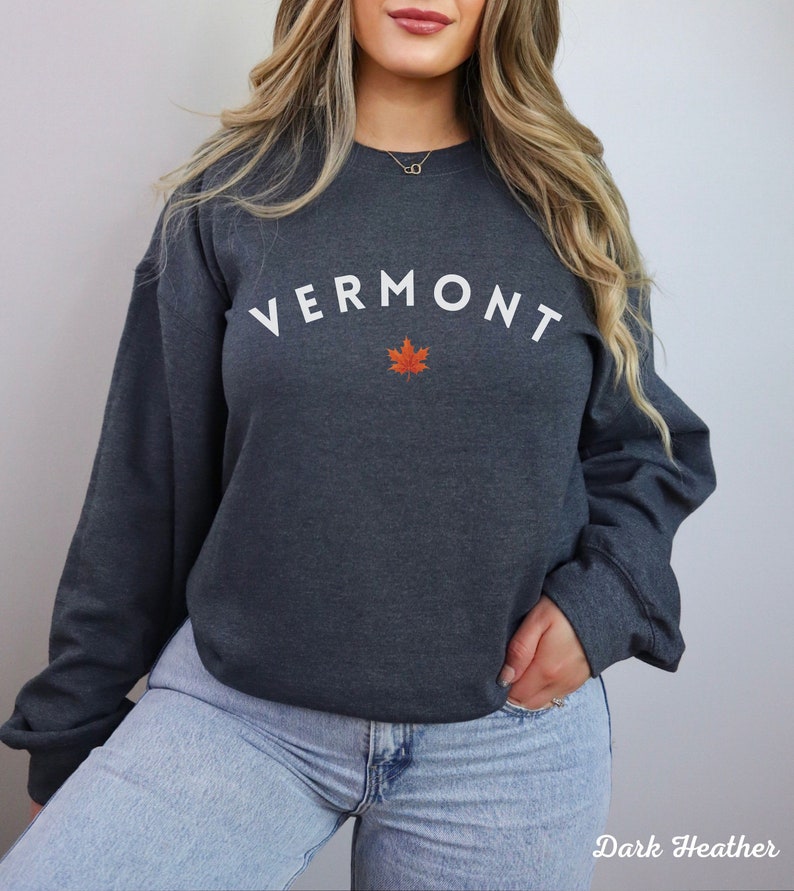May include: Dark heather grey sweatshirt with white text that reads "VERMONT" with a red maple leaf underneath.