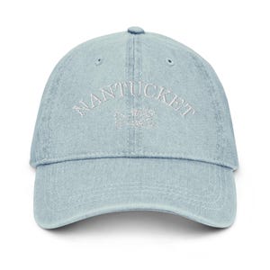 May include: A light blue denim baseball cap with white embroidered text that reads "NANTUCKET".