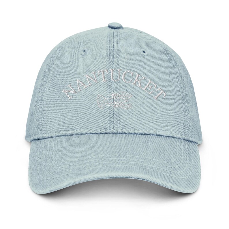 May include: A light blue denim baseball cap with white embroidered text that reads "NANTUCKET".