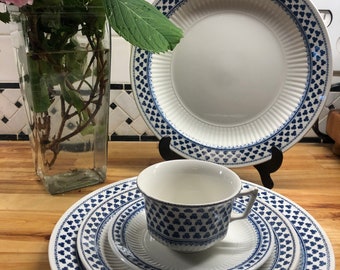 May include: A set of blue and white patterned ceramic dinnerware, including a dinner plate, a salad plate, a saucer, and a teacup.
