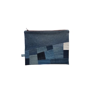 Könnte beinhalten: Eine blaue Jeans-Clutch mit Reißverschluss aus Patchwork-Stoff. Die Clutch ist aus verschiedenen Blautönen von Jeans gefertigt und hat einen weißen Patch.