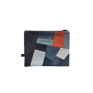 Könnte beinhalten: Eine Patchwork-Clutch aus Jeans mit Reißverschluss. Die Tasche ist aus verschiedenen Blautönen von Jeans gefertigt und hat ein einzelnes orangefarbenes Panel.