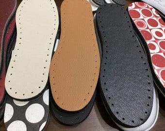 May include: Close-up of five different shoe soles. The soles are made of leather and have a variety of colors and patterns. The soles are all in good condition and ready to be used.