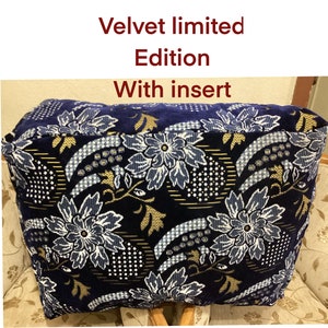 Op de afbeelding: Een blauwe fluwelen kussenhoes met een bloemenpatroon in wit en goud. De hoes heeft de tekst "Velvet limited Edition With insert" erop gedrukt.