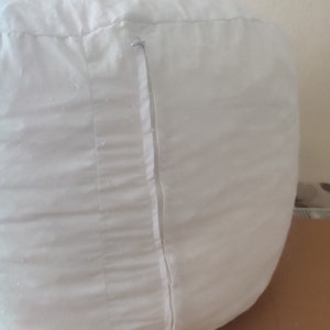 Puede incluir: Sill&oacute;n de puf blanco con cierre de cremallera.