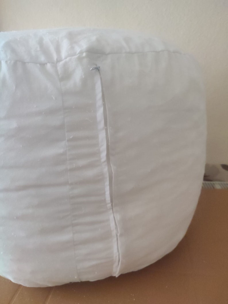 Puede incluir: Sill&oacute;n de puf blanco con cierre de cremallera.