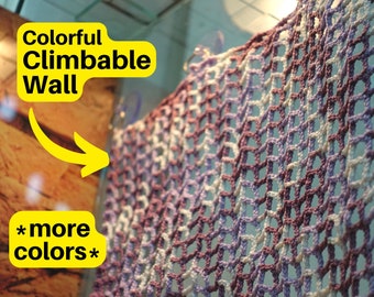 May include: A colorful, crocheted climbing wall with a sign that reads "Colorful Climbable Wall *more colors*"