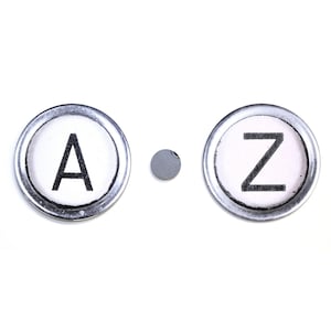 May include: Two round, silver-rimmed keys with white backgrounds and black letters. The key on the left says "A" and the key on the right says "Z".