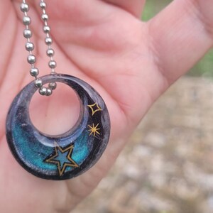 Pendant contains a lock of hair and a military star and some more stars, customizable.