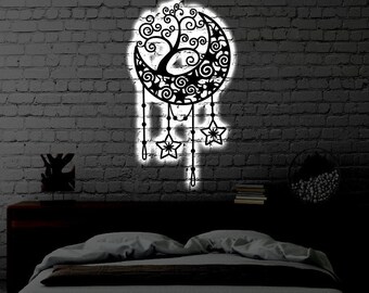 May include: A black wall-mounted metal art piece featuring a crescent moon and a tree with swirling branches. The design includes hanging star-shaped ornaments and is illuminated from behind by a bright white light, creating a glowing silhouette.