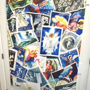 May include: A fabric panel adorned with a collage of vintage postage stamps. The stamps showcase angels, religious figures, and landscapes in shades of blue, white, and gold. Some stamps display text such as "LATVIJA 3" and "BARBADOS".