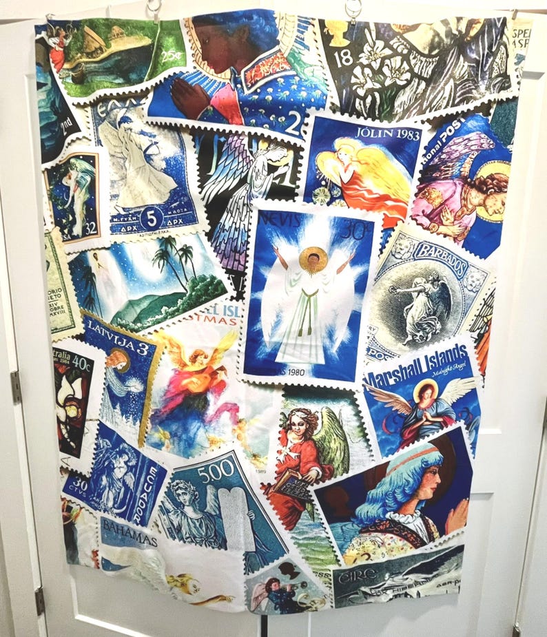 May include: A fabric panel adorned with a collage of vintage postage stamps. The stamps showcase angels, religious figures, and landscapes in shades of blue, white, and gold. Some stamps display text such as "LATVIJA 3" and "BARBADOS".