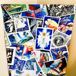 May include: A fabric panel adorned with a collage of vintage postage stamps. The stamps, in various sizes and shapes, depict angels, religious figures, and tropical scenes. Predominantly blue, white, and gold, the stamps are arranged on a white background.