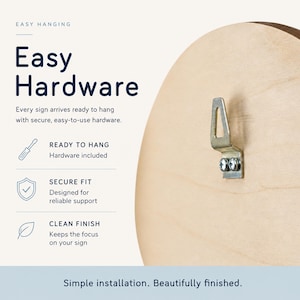 May include: A light-colored wooden circular sign back featuring a metal triangular hanging bracket attached with two silver screws. The text reads Easy Hanging, Easy Hardware, Every sign arrives ready to hang with secure, easy-to-use hardware.