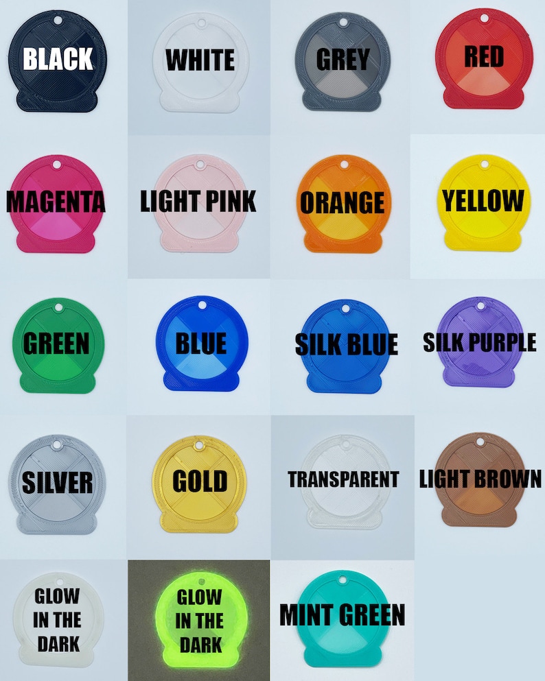 May include: A collection of 17 round plastic keychains in various colors, including black, white, grey, red, magenta, light pink, orange, yellow, green, blue, silk blue, silk purple, silver, gold, transparent, light brown, glow in the dark green, and mint green. Each keychain has a different color and features the color name printed in black text.