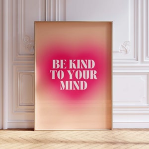 May include: A framed poster with a pink and orange gradient background. The text "BE KIND TO YOUR MIND" is printed in white on the poster.